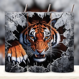 May include: Three stainless steel tumblers with a tiger face breaking through a cracked wall design. The tiger has orange and black stripes and a fierce expression.