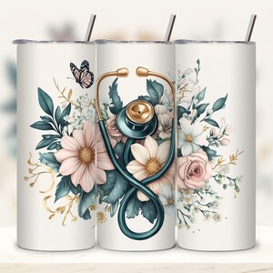 Puede incluir: Un vaso de acero inoxidable blanco con un dise&ntilde;o floral y un estetoscopio. Las flores son rosas, blancas y verdes. Hay una mariposa dorada en el lado izquierdo del vaso.