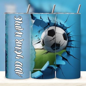 May include: A blue tumbler with a soccer theme. The design features a soccer ball bursting through a cracked blue surface, with the text "ADD YOUR NAME" on the side. Includes a silver straw.