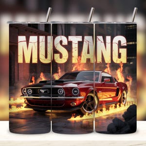 May include: A stainless steel tumbler featuring a red Mustang car engulfed in flames, with the word "MUSTANG" in large, glowing letters above. The design includes a black hood and wheels, set against a city backdrop.