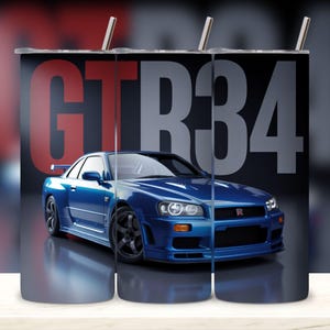 May include: A blue tumbler featuring a blue sports car with the text "GTR R34" in red and white. The car is a sleek, modern design with black wheels and a glossy finish. The background is dark.