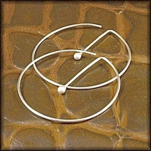 May include: A pair of silver hoop earrings with small silver beads at the top of each hoop.