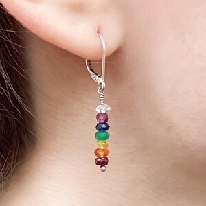 May include: A silver leverback earring featuring a vertical drop design with a series of small, faceted, multi-coloured gemstone beads in shades of clear, purple, blue, green, yellow, orange, and red, finished with a small silver bead at the base.