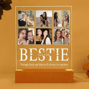 Könnte beinhalten: Ein weißes beleuchtetes Schild mit Holzsockel zeigt eine Collage aus sechs Fotos von Freunden. Das Schild lautet "BESTIE Grace & Lily Through thick and thin, we'll always be together."