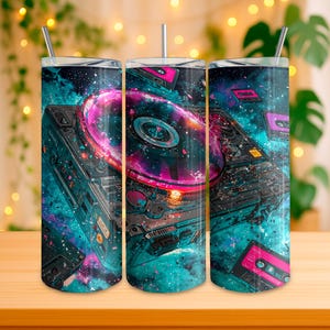 May include: Three stainless steel tumblers with a vibrant design featuring a DJ turntable, cassette tapes, and a cosmic background in shades of teal, pink, and purple. Each tumbler has a silver straw.