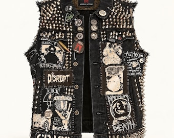 May include: A black denim vest featuring silver metal spikes on the shoulders and sides. The vest is heavily decorated with various band patches, including text reading Disrupt, Doom, and Crass, along with several circular pins and a bullet accessory.