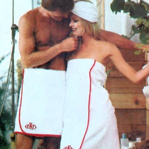 Peut inclure: Patron Butterick 3532. L'image montre un homme et une femme portant des serviettes blanches avec une bordure rouge et les lettres brodées "<ekr>". La femme porte un bandeau blanc assorti. L'homme porte un short blanc avec une bordure rouge. Des pantoufles blanches sont également visibles.