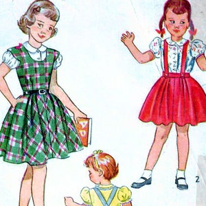 May include: Simplicity Printed Pattern 2933, size 2, for a dress with a skirt and a separate blouse. The pattern includes instructions for making a dress with a plaid skirt and a white blouse, a dress with a red skirt and a white blouse, and a dress with a blue skirt and a white blouse. The pattern also includes instructions for making a separate blouse and skirt.