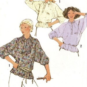 May include: Simplicity sewing pattern number 8885 for a blouse with a gathered neckline and long sleeves. The pattern includes three different views: a white blouse with a gathered neckline and long sleeves, a purple blouse with a gathered neckline and long sleeves, and a floral print blouse with a gathered neckline and long sleeves.