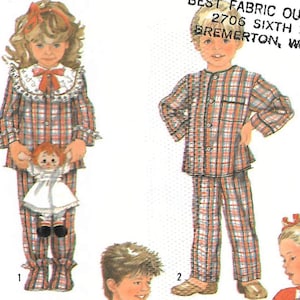 May include: Illustration of children's pajamas in a red, white, and blue plaid pattern. One child is holding a doll. The image includes the text "BEST FABRIC OUTLET 2706 SIXTH ST BREMERTON, WA".