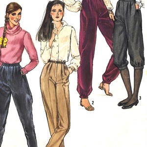 May include: Illustration of three women modeling different styles of pants and tops. The first woman wears a pink turtleneck and dark blue pants. The second woman wears a white button-down shirt and tan pants. The third woman wears a white blouse and burgundy pants.