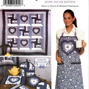 May include: A Simplicity Quilt Block Club pattern for a home decor project. The pattern includes instructions for making a quilt, an apron, and pot holders. The quilt features a heart and windmill design. The pattern is printed on a white background with blue and black text.