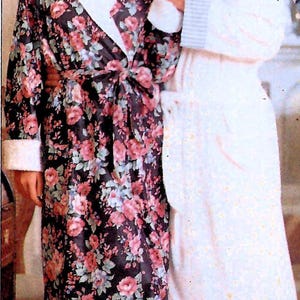 May include: A couple in matching robes. One robe is black with a pink floral pattern, white trim, and a matching tie. The other is white with a light blue stripe pattern and a pocket. The couple is holding hands.