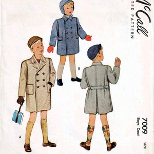 Puede incluir: Un patr&oacute;n de costura vintage de McCall's para un abrigo de ni&ntilde;o. El patr&oacute;n es para la talla 2, 35c. El patr&oacute;n muestra tres estilos diferentes de abrigos, todos con cierres de doble botonadura. Los abrigos se muestran en azul, beige y gris.