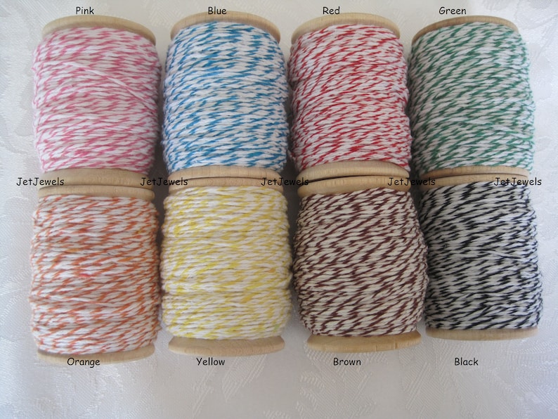 Puede incluir: Una colecci&oacute;n de ocho carretes de hilo en varios colores: rosa, azul, rojo, verde, naranja, amarillo, marr&oacute;n y negro. Cada carrete est&aacute; etiquetado con su color y la marca "Jet Jewels". El hilo est&aacute; enrollado en carretes de madera.