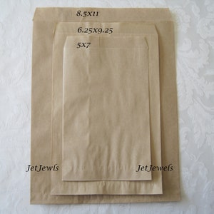May include: Three brown paper bags of different sizes, labeled with their dimensions: 5x7, 6.25x9.25, and 8.5x11. The bags are all folded and have a slight crease down the middle. The text "Jet Jewels" is printed on the bottom of the two larger bags.