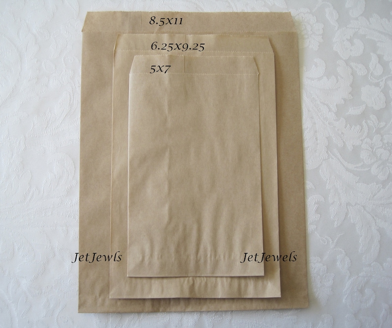 May include: Three brown paper bags of different sizes, labeled with their dimensions: 5x7, 6.25x9.25, and 8.5x11. The bags are all folded and have a slight crease down the middle. The text "Jet Jewels" is printed on the bottom of the two larger bags.