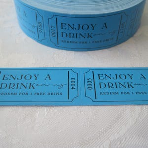 Op de afbeelding: Een rol blauwe papieren tickets met de tekst "ENJOY A DRINK on us" en "REDEEM FOR 1 FREE DRINK".