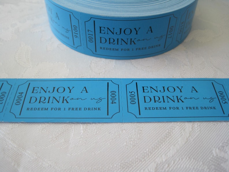 Op de afbeelding: Een rol blauwe papieren tickets met de tekst "ENJOY A DRINK on us" en "REDEEM FOR 1 FREE DRINK".