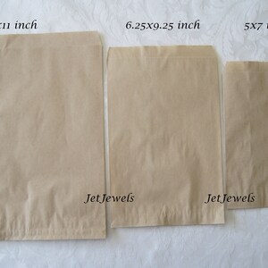 May include: Three brown paper bags of different sizes. The bags are labeled with their dimensions in inches: 8.5x11 inch, 6.25x9.25 inch, and 5x7 inch. The bags are on a white surface. The text "Jet Jewels" is printed on the bottom of the two larger bags.