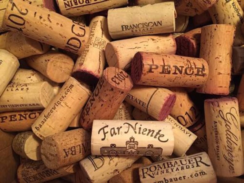 May include: A collection of used wine corks, featuring various brands and years. The corks are primarily light brown with printed text in black and red, including "PENCE" and "Far Niente".