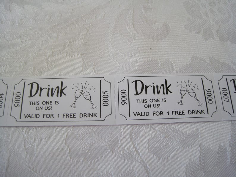 Puede incluir: Dos tickets de bebida blancos con texto negro y un gr&aacute;fico de dos copas de champ&aacute;n brindando. El texto dice "Drink This one is on us! Valid for 1 free drink".