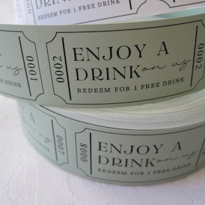 Puede incluir: Un rollo de tickets de bebida de papel verde con el texto "Enjoy a Drink on us" y "Redeem for 1 free drink".