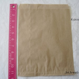 May include: A brown paper bag measuring 8.5 by 11 inches. The bag is flat and has a slight crease down the middle.