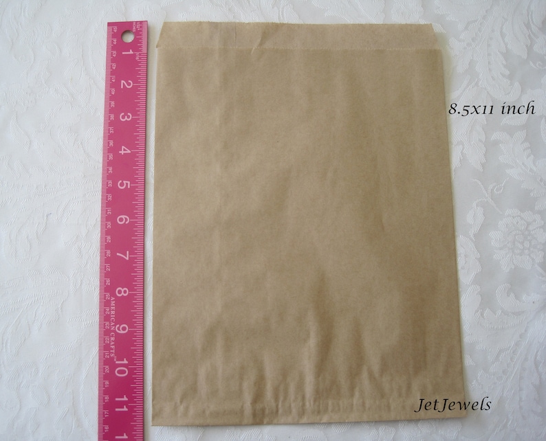 May include: A brown paper bag measuring 8.5 by 11 inches. The bag is flat and has a slight crease down the middle.