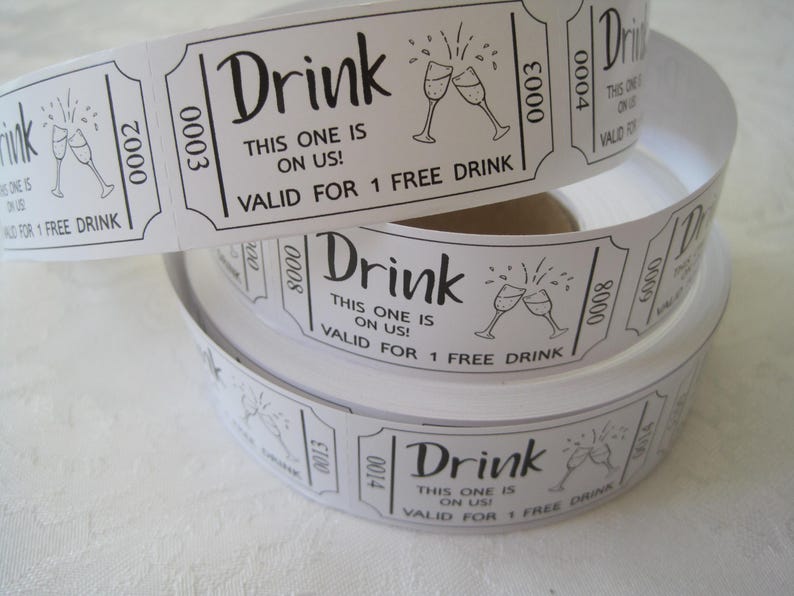 Op de afbeelding: Een rol witte papieren dranktickets met zwarte tekst en een afbeelding van twee champagne glazen. De tekst luidt "Drink This one is on us! Valid for 1 free drink".