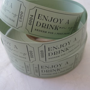 Puede incluir: Un rollo de tickets de bebida verdes con el texto "ENJOY A DRINK on us" y "REDEEM FOR 1 FREE DRINK".