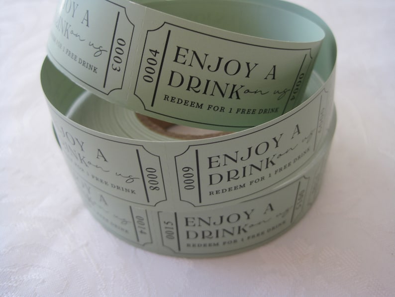 Puede incluir: Un rollo de tickets de bebida verdes con el texto "ENJOY A DRINK on us" y "REDEEM FOR 1 FREE DRINK".