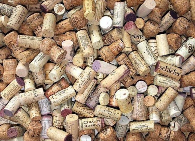 May include: A collection of used wine corks, featuring various shapes, sizes, and colors. The corks display printed text and markings, with shades of brown, beige, and hints of purple. The image showcases a variety of wine-related items.