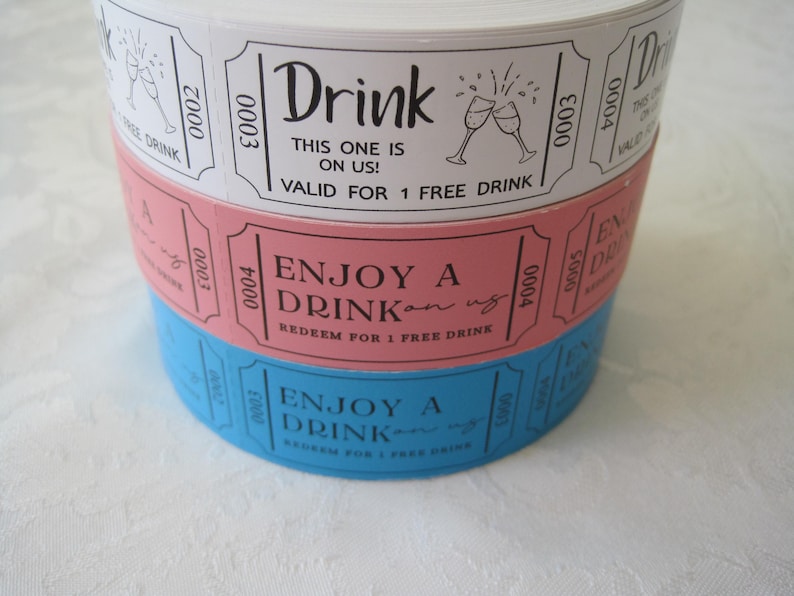 Op de afbeelding: Drie gestapelde papieren dranktickets met een wit, roze en blauw ontwerp. Het bovenste ticket zegt "Drink This one is on us! Valid for 1 free drink". Het middelste ticket zegt "Enjoy a Drink on us. Redeem for 1 free drink". Het onderste ticket zegt "Enjoy a Drink on us. Redeem for 1 free drink".