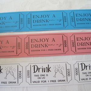 Op de afbeelding: Zes roze en blauwe papieren dranktickets met de tekst "Geniet van een drankje op ons!" en "Inwisselen voor 1 gratis drankje". Drie witte papieren dranktickets met de tekst "Drink, het is voor ons!" en "Geldig voor 1 gratis drankje".