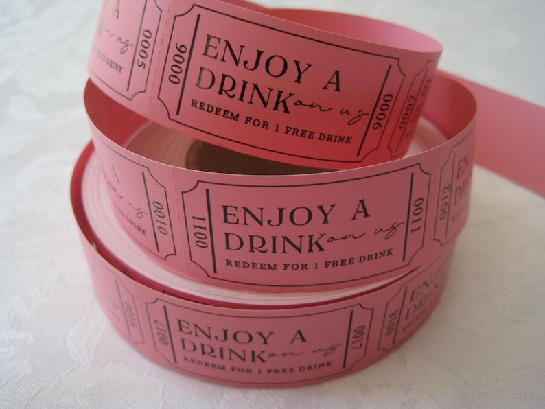 Op de afbeelding: Roze papieren roltickets met de tekst "Enjoy a Drink" en "Redeem for 1 Free Drink".