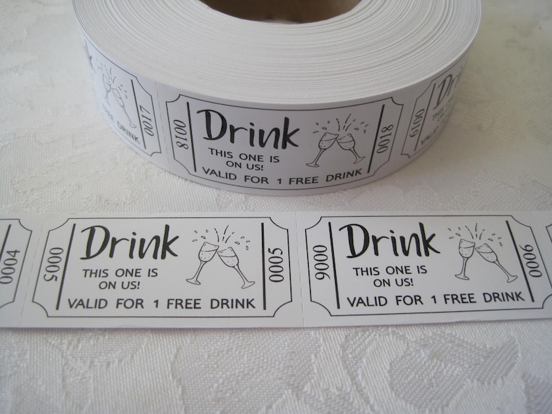 Op de afbeelding: Een rol witte dranktickets met zwarte tekst die "Drink This one is on us! Valid for 1 free drink" luidt. De tickets bevatten een zwart-witte illustratie van twee champagne glazen die klinken.