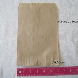 May include: A brown paper bag measuring 6.25 inches by 9.25 inches. The bag is flat and has a folded top.