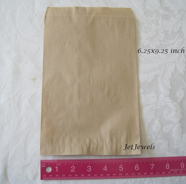 May include: A brown paper bag measuring 6.25 inches by 9.25 inches. The bag is flat and has a folded top.