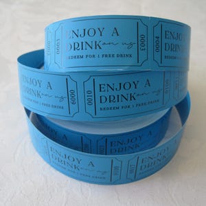 Op de afbeelding: Een stapel blauwe papieren tickets met de tekst "Enjoy a Drink on us" en "Redeem for 1 Free Drink".