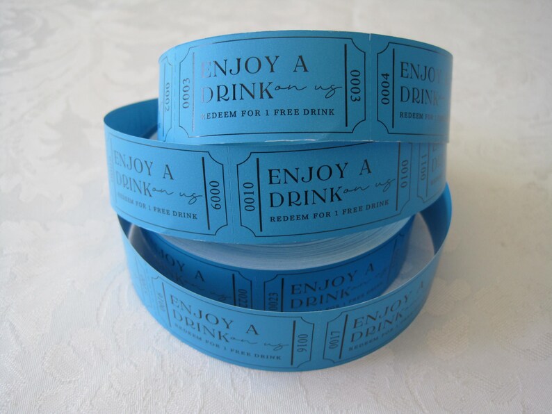 Op de afbeelding: Een stapel blauwe papieren tickets met de tekst "Enjoy a Drink on us" en "Redeem for 1 Free Drink".