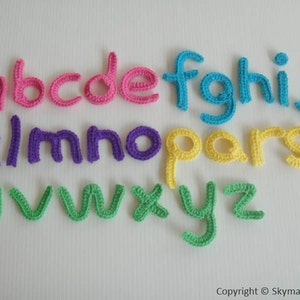Peut inclure: Un ensemble de lettres de l'alphabet en crochet de différentes couleurs, de a à z, en rose, violet, jaune et vert.