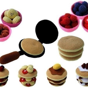 Könnte beinhalten: Ein Set an gehäkelten Pfannkuchenspielzeugen, darunter eine Bratpfanne, ein Stapel Pfannkuchen und Schalen mit verschiedenen Belägen wie Blaubeeren, Erdbeeren und Schokoladenstückchen.