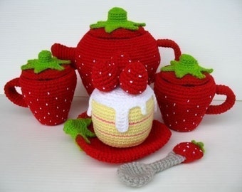 May include: A red crocheted strawberry tea set with a teapot, two cups, a sugar bowl, a cake, and a spoon. The set is perfect for pretend play.