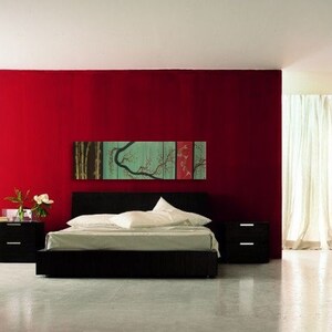 May include: A black platform bed with white bedding and a red wall behind it. A multi-panel artwork with a green tree and red fish hangs above the bed.