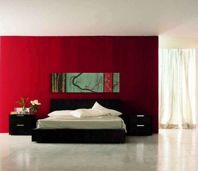 May include: A black platform bed with white bedding and a red wall behind it. A multi-panel artwork with a green tree and red fish hangs above the bed.