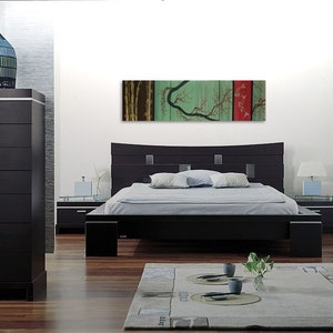 May include: A black platform bed with a curved headboard and a green and red abstract painting above it. The painting features a stylized tree with branches and leaves.