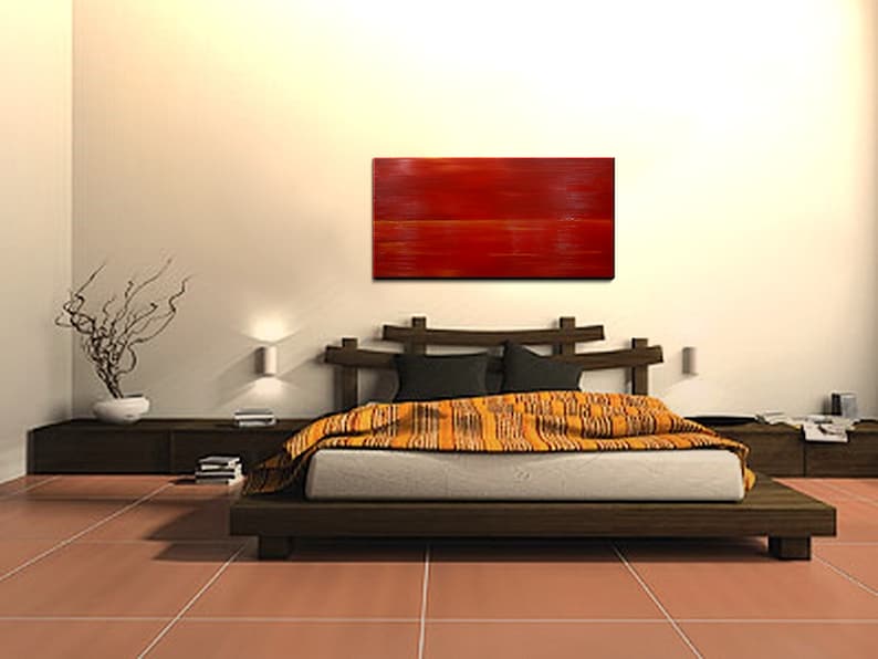 K&ouml;nnte beinhalten: Ein modernes Schlafzimmer mit einem Holzbettgestell und einem roten abstrakten Gem&auml;lde an der Wand. Das Bett hat eine gelbe und orangefarbene gemusterte Decke und ein braunes Holz-Kopfteil.