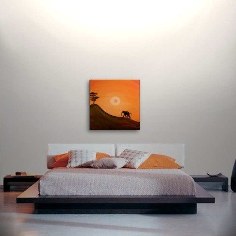 May include: A painting of an elephant walking on a hill with a tree in the background. The sky is orange and the sun is setting.