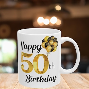 May include: White ceramic mug with a black and gold design. The mug says "Happy 50th Birthday" with gold balloons.